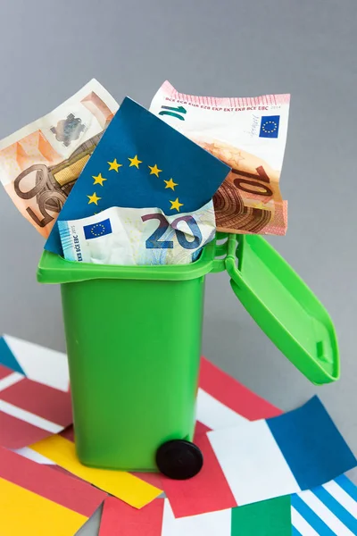 flags of the countries of the European Union, euro banknotes in the garbage can. concept of crisis