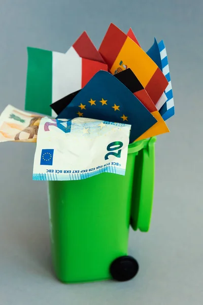 flags of the countries of the European Union, euro banknotes in the garbage can. concept of crisis
