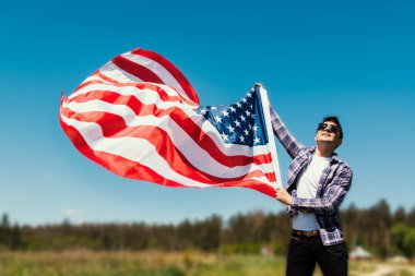 Mutlu 4 Temmuz kartı. adam Amerikan ABD bayrağı, tonlu görüntü sallayarak tutuyor 