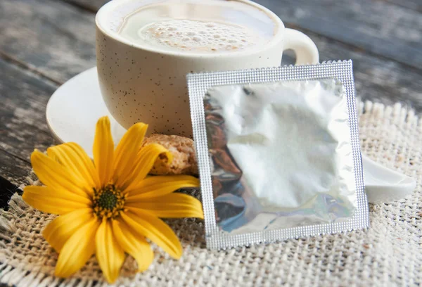 condom with flower and coffee - dating, making love concept