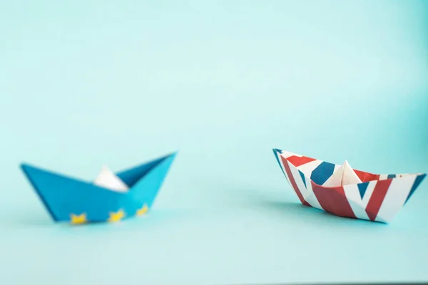 paper ships from the flags of the European Union and the UK on a blue background, concept of an agreement on Brexit