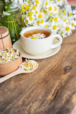 Beyaz arka plan doktoru tedavisi ve bağışıklık konsepti, ilaç - halk, alternatif, tamamlayıcı, geleneksel tıp üzerine bir fincan papatya çayı ve papatya çiçeği.