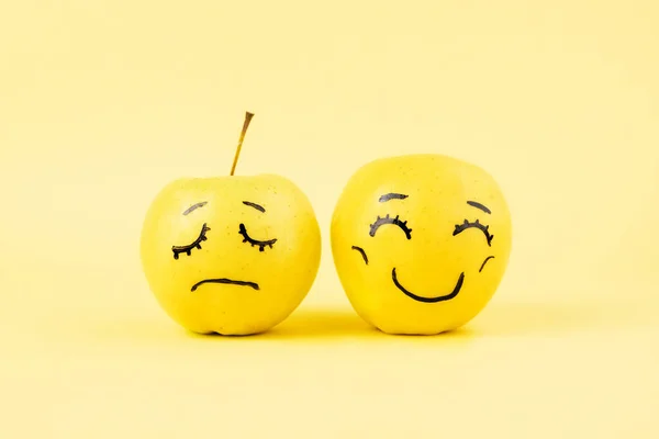 different emotions fromhappy smile joy to sadness and anger Face on an apples - abstract image of human emotions on blue background