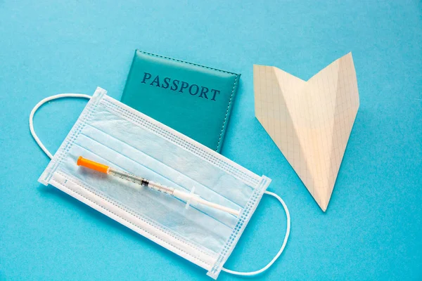 medical face mask, paper plane, passport. new flight rules travel concept traveling abroad during coronavirus pandemic