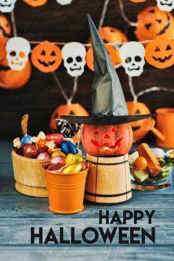 Cadılar Bayramı Jack o Fener kabağı ve cadı şapkası, arka planda yarasalardan ve kafatasından bir çelenk