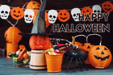 Cadılar Bayramı Jack o Fener kabağı ve cadı şapkası, arka planda yarasalardan ve kafatasından bir çelenk