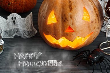 Cadılar Bayramı Jack o Lantern balkabağı sisli bir arka planda. Mumların, örümceklerin, cadılar bayramı şakalarının ya da süslemelerinin etrafında