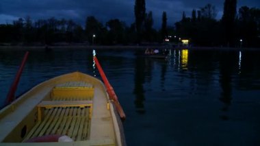 Gece parkındaki gölde tekne yüzüyor..