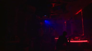 İnsanlar kulüpte müzikle dans ediyor. Saksafon çalmak ve dans etmek.