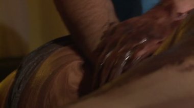 Masaj terapisti çikolata masajı yapar.