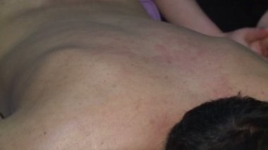 İki masaj terapisti özel masaj odalarında bir adama ve bir kadına masaj yapıyor..