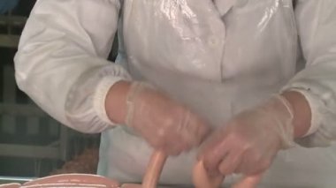 Sosis üretimi. Et ve yağ özel bir makinede öğütülür. Sonuçlar üretken atölyeye gönderiliyor. Özel makineler sosis pişirir. Bitmiş ürün kurutucuya gönderilir..