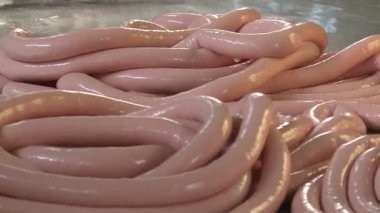 Sosis üretimi. Et ve yağ özel bir makinede öğütülür. Sonuçlar üretken atölyeye gönderiliyor. Özel makineler sosis pişirir. Bitmiş ürün kurutucuya gönderilir..