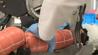 Sosis üretimi. Et ve yağ özel bir makinede öğütülür. Sonuçlar üretken atölyeye gönderiliyor. Özel makineler sosis pişirir. Bitmiş ürün kurutucuya gönderilir..