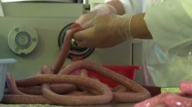 Sosis üretimi. Et ve yağ özel bir makinede öğütülür. Sonuçlar üretken atölyeye gönderiliyor. Özel makineler sosis pişirir. Bitmiş ürün kurutucuya gönderilir..