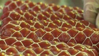 Sosis üretimi. Et ve yağ özel bir makinede öğütülür. Sonuçlar üretken atölyeye gönderiliyor. Özel makineler sosis pişirir. Bitmiş ürün kurutucuya gönderilir..