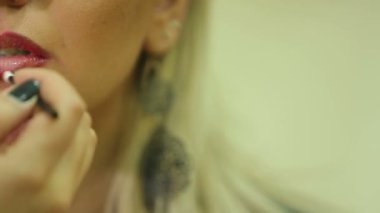 Makyöz kız yapar, ruj sürer.