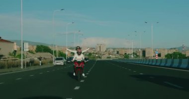 Gün batımında motosiklet süren aşık çift.