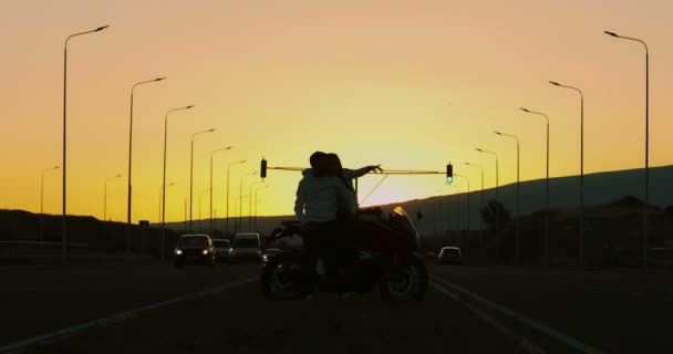 Para Zakochana Stojąca Obok Motocykla Podczas Zachodu Słońca — Wideo stockowe