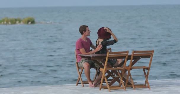 海の近くのマリーナに座って愛のカップル 風景を鑑賞 お互いに話をし 楽しみを持っています — ストック動画