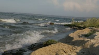 Dalgalar kumsalda ve kayalarda kırılıyor dalgalar farklı açılardan iniyor.,