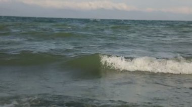 Dalgalar kumsalda ve kayalarda kırılıyor dalgalar farklı açılardan iniyor.,