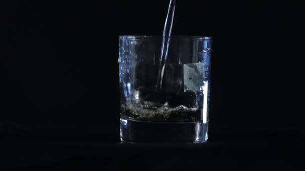 在黑色的背景前 威士忌被倒入威士忌的石头中 — 图库视频影像