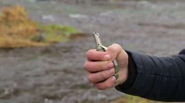 Bir adam el bombasını çeker, diğeri elini tutar.