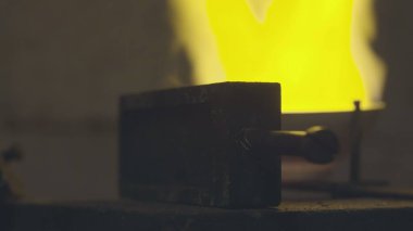 Kuyumcu gümüşü ateşte eritiyor. Ve özel formlara döküldü..