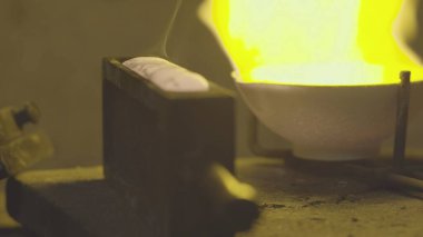 Kuyumcu gümüşü ateşte eritiyor. Ve özel formlara döküldü..