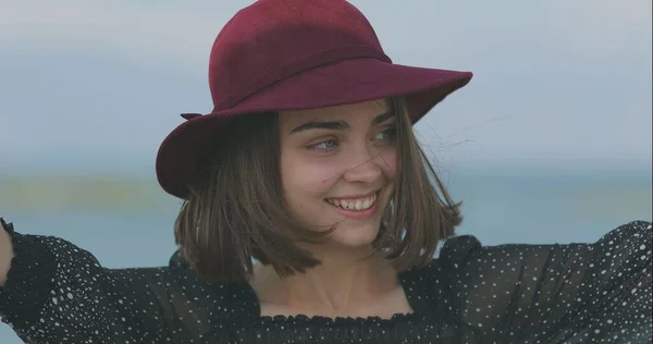 모자를 아름다운 소녀는 미소를 장난을 칩니다 — 스톡 사진