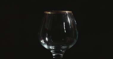 Kırmızı şarabı bir bardağa dolduruyorum, siyah arkaplanın önünde.