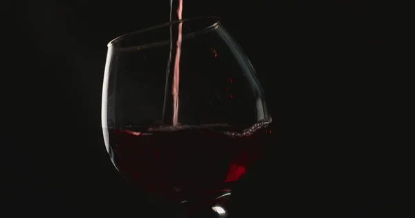 Versare Vino Rosso Bicchiere Davanti Allo Sfondo Nero — Foto Stock