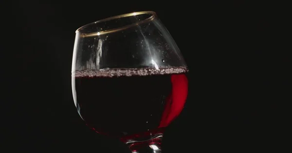 Wlewanie Czerwonego Wina Kieliszka Przed Czarnym Tłem — Zdjęcie stockowe