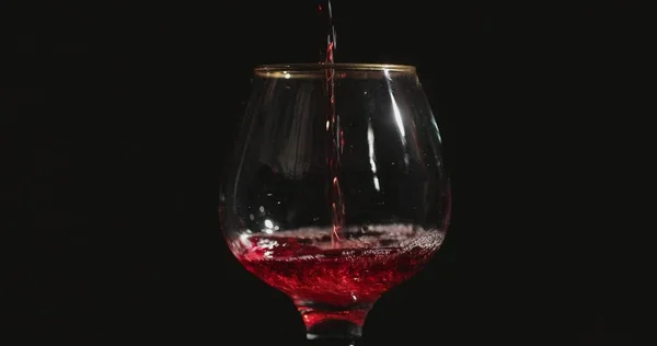 Despeje Vinho Tinto Copo Frente Fundo Preto — Fotografia de Stock