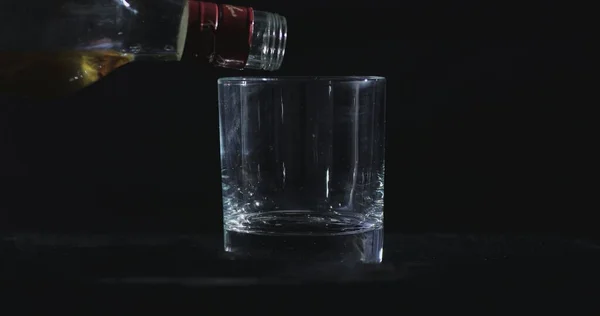 Μπροστά Από Ένα Μαύρο Φόντο Ουίσκι Χύνεται Ένα Ποτήρι — Φωτογραφία Αρχείου