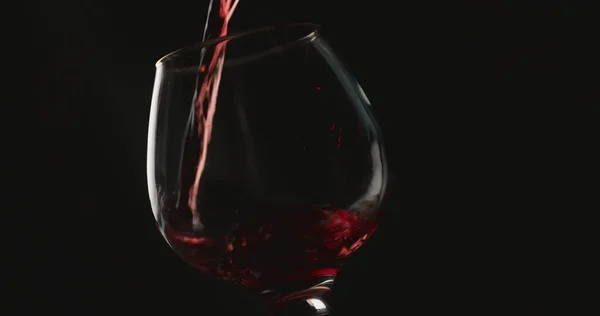 Ρίχνει Κόκκινο Κρασί Ένα Ποτήρι Μπροστά Από Μαύρο Φόντο Royalty Free Φωτογραφίες Αρχείου