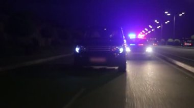 Yan aynada bir polis arabası otoyolda bir arabayı kovalıyor. Polis takibi, araba kovalamacadan kaçıyor.