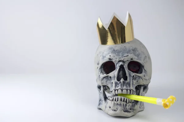 Halloween humano imitação do crânio cinza com tubo festivo na boca e coroa dourada na cabeça. Decoração para feriado Halloween. O conceito de férias eternas . — Fotografia de Stock