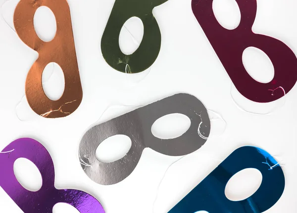 Multicolored carnival masks lying on a white background. Flat style. View from above. — Stock Photo, Image