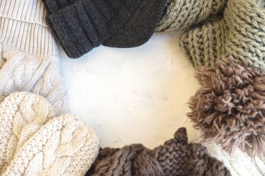 Rahat düz yatıyordu. Sıcak kış ve sonbahar giyim: kazak, eşarp, eldiven beyaz beton dokusal arka planda. Süslemeleri için tatil.