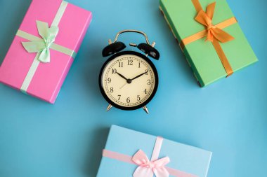 Şenlikli tatil yeni yıl ve Noel hediye kutuları, çalar saat ile arka plan mavi. Karnaval, Doğum günü, parti kavramı. Düz yatıyordu. Üstten görünüm.