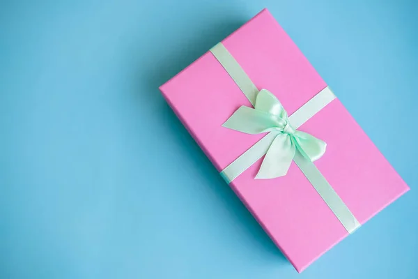 Fiesta festiva de Año Nuevo y Navidad fondo azul con caja de regalo rosa. Concepto de carnaval, cumpleaños, fiesta. Acostado. Vista superior . — Foto de Stock