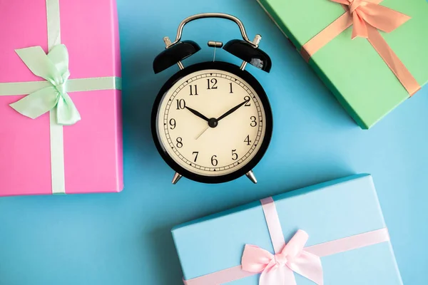 Festive holiday New Year and Christmas blue background with gift boxes, alarm clock. Concept of carnival, birthday, party. Flat lay. Top view. Stock Picture