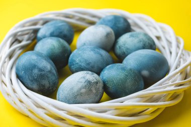 El çelenk parlak sarı zemin üzerine mavi Paskalya yumurta boyalı. Paskalya bahar tatil kavramı.