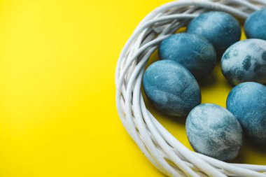 El çelenk parlak sarı zemin üzerine mavi Paskalya yumurta boyalı. Paskalya bahar tatil kavramı.