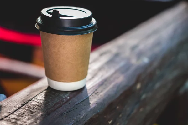 Кофейная чашка ремесла стоит на деревянной поверхности на размытом фоне. Место для текста или логотипа . — стоковое фото