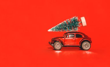 Ahşap taban ve kırmızı araba üzerinde Minyatür oyuncak yapay Çam ağacı, uzun gölge kaplama ile parlak kırmızı Noel arka plan. Yeni Yıl Kavramı, Noel, tebrik kartı.