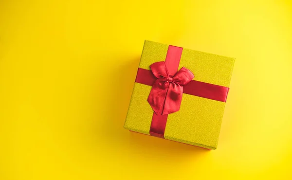 Caja de regalo sobre fondo amarillo soleado. El concepto del Año Nuevo, Navidad, Cumpleaños, Aniversario. Vista superior. Aplanado . — Foto de Stock