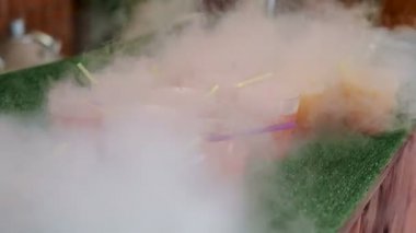 Kadın barmen el termos sigara kokteyl döker. Tüpleri yeşil arka plan üzerinde durmak ile çok renkli bardak.